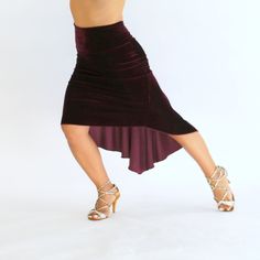 a woman in a skirt and heels is dancing with her legs spread out to the side