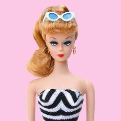 a barbie doll wearing sunglasses and a black and white dress with blue circles on her eyes