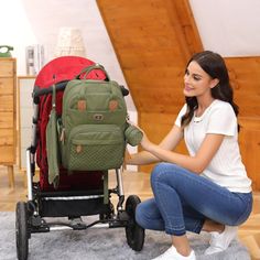 a woman kneeling down next to a stroller with a backpack on it's back