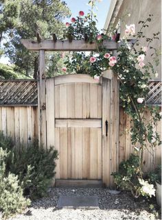 a wooden gate with flowers growing over it