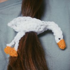 there is a crocheted duck on the back of a woman's head