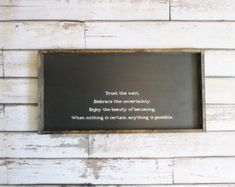 a sign on the side of a white wooden wall