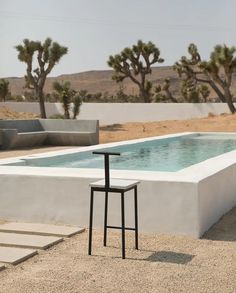 a chair sitting next to a pool in the desert