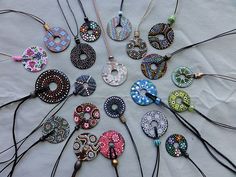 a group of necklaces sitting on top of a white cloth covered table next to each other