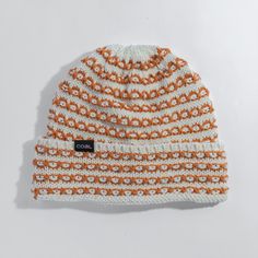 an orange and white knitted beanie hat on a white background with the word cool written across it