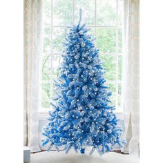 a blue christmas tree in front of a window