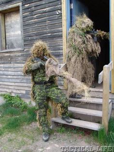 a man in camouflage holding something up to his face