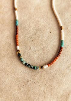 the necklace is made with beads and glass beaded in gold, silver, and turquoise