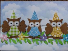 three owls are sitting on a branch with flowers and leaves around them, one is wearing a party hat