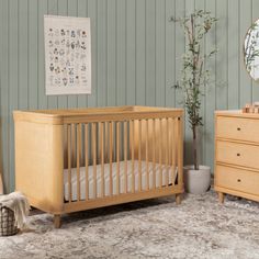 a baby's room with a crib, dresser and mirror on the wall