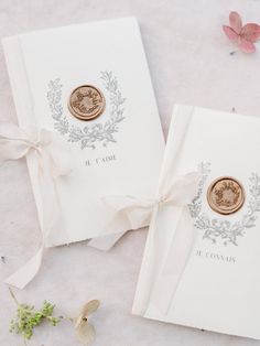 two wedding cards with wax stamp and ribbon tied around the edges, sitting next to each other