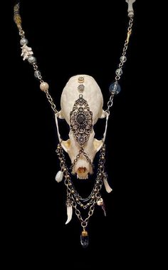 This elaborate charivari inspired necklace is composed from an authentic american Pine Marten skull that is decorated with bronze filigree, stones, chain across its face, two bronze rings on its fangs and multiple chains that's draped beneath it intertwined with pearls, a coyote claw, a mink fang, a fox toe bone and a gorgeous quartz crystal! This unique necklace hangs from a long chain paired with beads, vertebrae, a tail bone and antique gold findings. Skull Staff, Tail Bone, Bronze Rings, Pine Marten, Bone Crafts, Animal Skull, Bronze Ring, Inspired Necklace, Skull Necklace