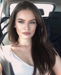 a woman sitting in the back seat of a car looking at the camera with an intense look on her face