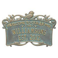 a metal sign that says welcome to our home, with a bird on the top