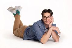 a man with glasses laying on the ground