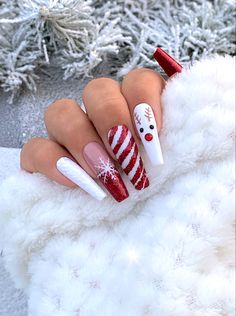 a woman's hand with red and white christmas themed nails