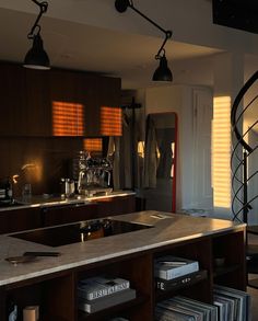 a kitchen with a spiral staircase in the center and lots of books on the counter