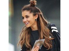 a woman with long hair is looking at something on her tablet while walking down the street