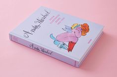 a book with an image of a woman on the front and back cover, sitting on a pink surface