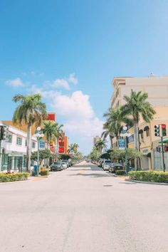 an empty street lined with palm trees and buildings