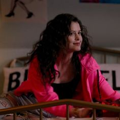 a woman sitting on top of a bed in a bedroom