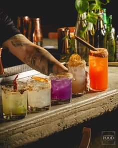 the bartender is making different kinds of cocktails on the bar counter with his hand