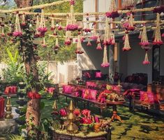 an outdoor area decorated with pink flowers and hanging decorations