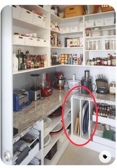 a kitchen with white cabinets and shelves filled with food