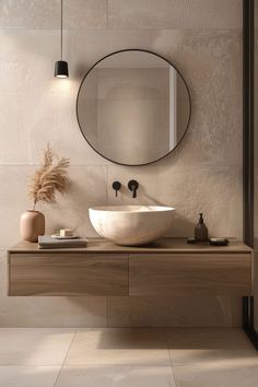 a bathroom with a round mirror above the sink