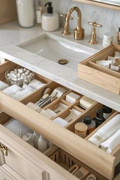 an open drawer in a bathroom filled with toiletries