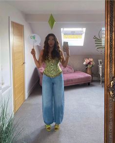 a woman standing in front of a mirror holding up a paper plate with an ornament on it