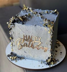 a birthday cake sitting on top of a plate with gold confetti around it