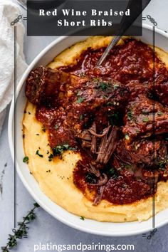 red wine braised short ribs in a bowl with mashed potatoes and parsley