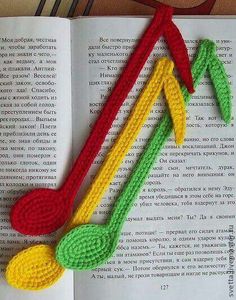 crocheted musical notes on top of an open book