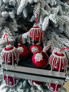 christmas ornaments are hanging from the tree in red and white colors with bead trim