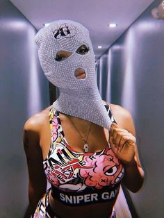 a woman wearing a silver mask and tank top