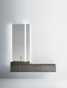 a bathroom sink with two mirrors and lights on the wall next to it in front of a white wall