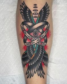 a tattoo on the leg of a person with an all seeing eye and arrows around it