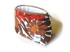 an orange and brown flowered purse on a white background with the word happy written in it