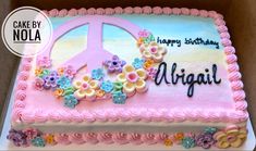 a birthday cake decorated with flowers and a peace sign