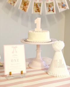 a first birthday cake on a table with decorations