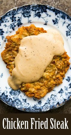 chicken fried steak with gravy on a blue and white plate