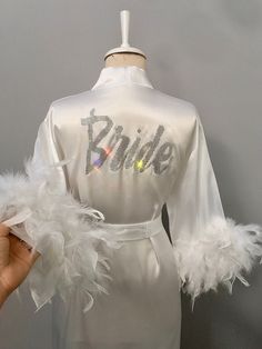 a white robe with silver sequins on the chest and name written on it