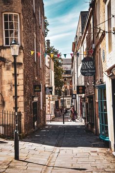 an alley way with buildings and flags on it