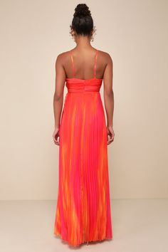 a woman in an orange and pink dress is looking down at the back of her dress