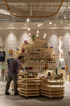 a man standing in front of a display of shoes and other items at a store