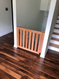 an empty room with hard wood floors and railings on the wall, next to stairs