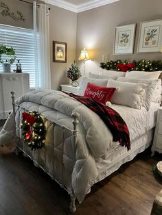 a bedroom decorated for christmas with white bedding and holiday decorations