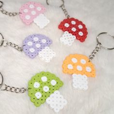 four plastic key chains with different designs on them, all in various colors and shapes