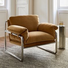 a brown chair sitting on top of a wooden floor next to a metal trash can